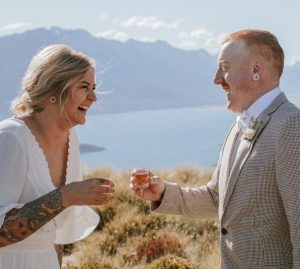 Elopement Couple for Queenstown Helicopter Wedding shot of whiskey laughing Lake Wakatipu