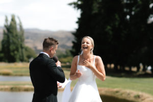 Groom saying vows to bride and bride laughing
