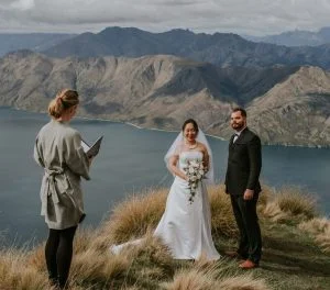 Coromandel Peak, Roy's Peak wedding elopement, helicopter wedding with Wanaka marriage celebrant Siobhain on mountaintop with Lake Wanaka in the backround. Couple smiling at wedding celebrant